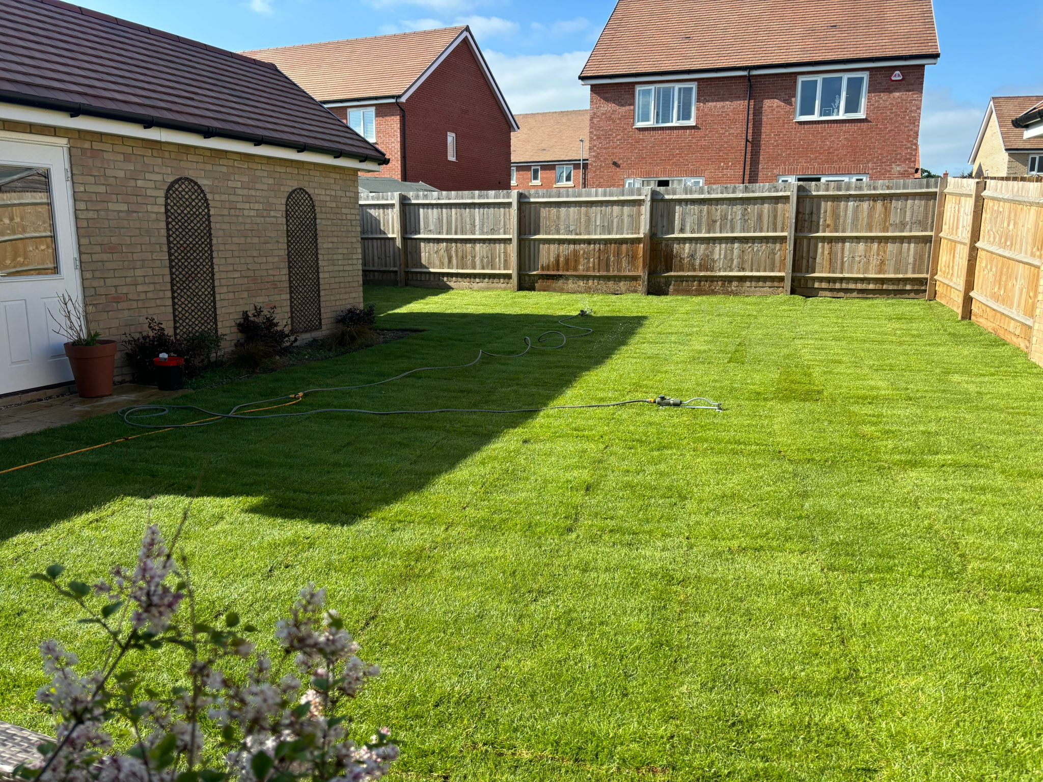 Pristine artificial turf lawn with modern fencing installation